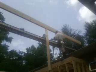 Carpenter setting a ridge beam over a new addition frame — Ice Dam Removal by Roofing Brothers in Columbia City