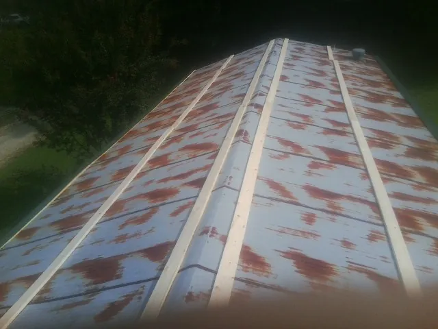 Rusted metal roof panels with new wood purlins before replacement — Storm Damage Roof Repair in Columbia City by Roofing Brothers
